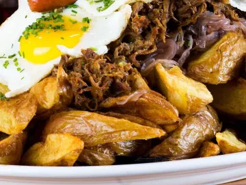 Tabla con papas fritas, carne mechada, huevo frito y vienesas